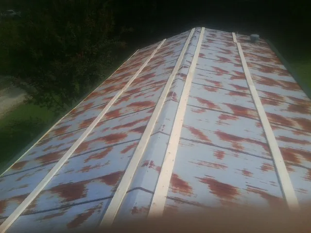 Rusted metal roof panels with new wood purlins before replacement — Storm Damage Roof Repair in Elk River by Roofing Brothers
